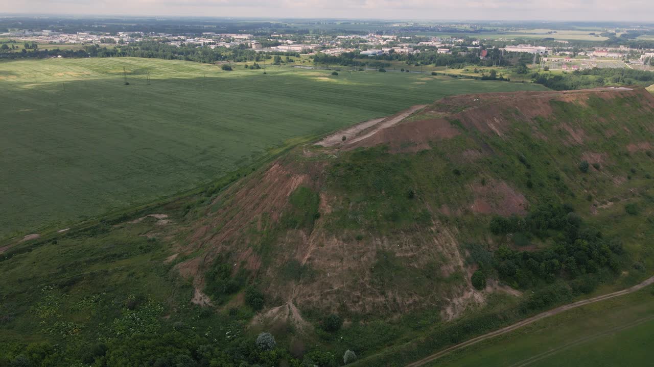 Household waste landfill. Closed for processing. Environment protection. Close-up shot. The city is visible on the horizon. Close-up shot. Aerial photography.