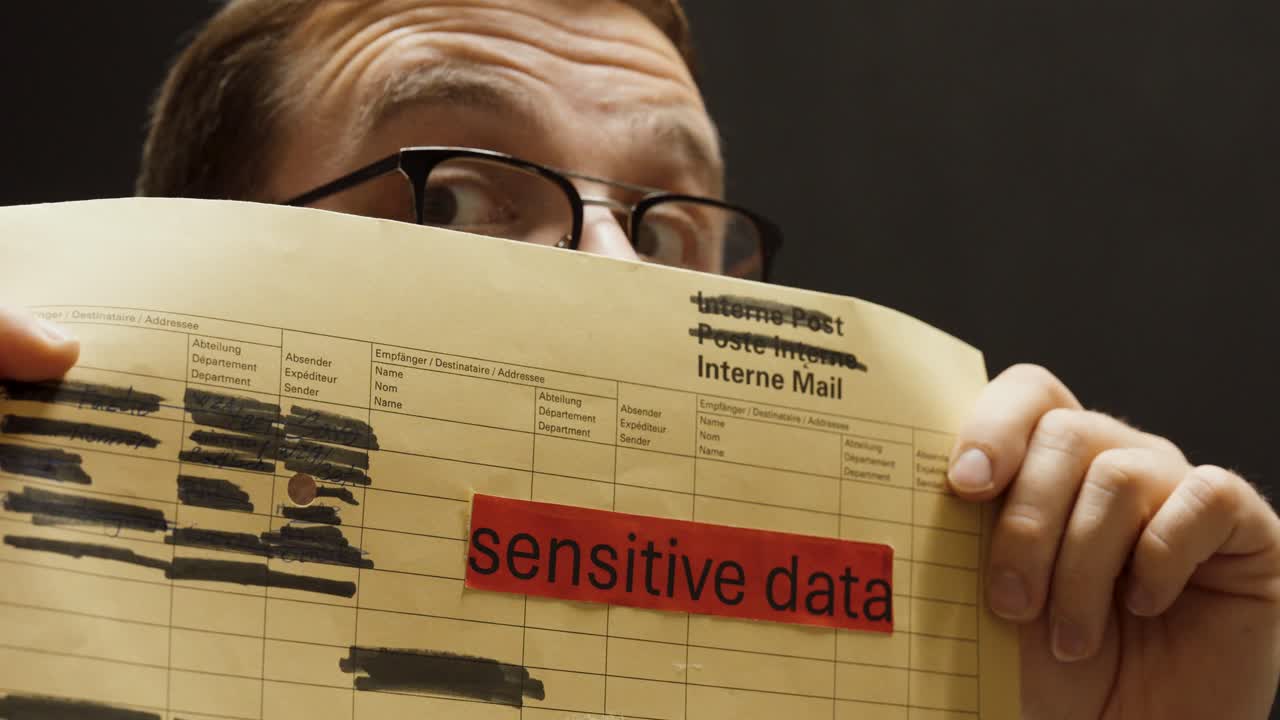 A person secretly looks inside an envelope labeled “sensitive data,” symbolizing data theft, corporate espionage, and violation of information security policies
