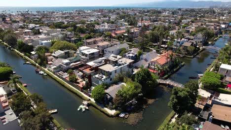 Rising-above-the-waterfront-homes-along-the-canals-at-Venice-Beach-Los-Angeles,-California---ascending-aerial-view