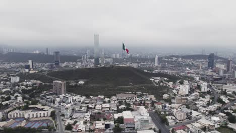 disparo de drones en un día nublado por la mañana en hasta bandera sobre el cerro obispado en la ciudad de monterrey, méxico-15