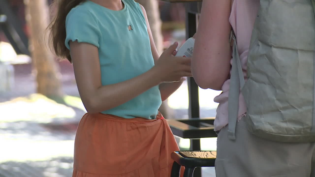 Woman and girl applying sun protection