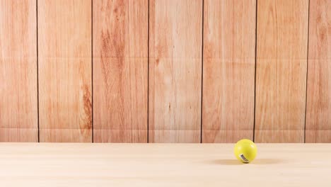 a yellow ball moves across a wooden background