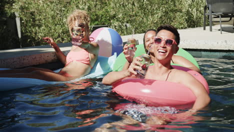 amigos diversos disfrutan de un día soleado en la piscina