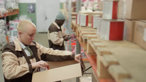 worker packing paint cans in a warehouse