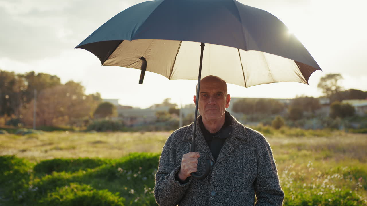 Strong Winter Sun Over a Man with an Open Umbrella in Nature