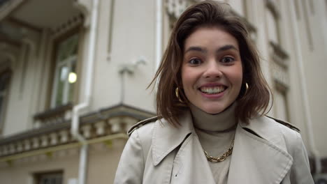 surprised woman looking camera outdoor. amazed girl covering mouth with hands.