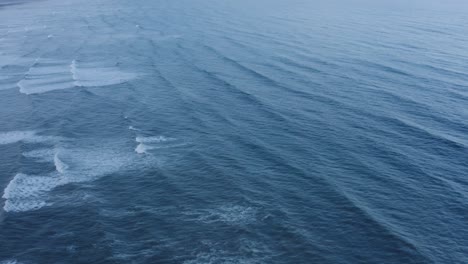 aerial ocean swell at dusk, tracking forward 4k