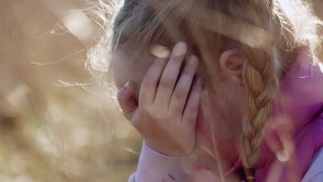 Portrait-of-a-crying-blonde-girl-in-the-middle-of-a-sunlit-meadow