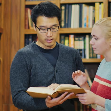 Lächelnder-Koreanischer-Mann,-Der-Mit-Einer-Frau-In-Der-Bibliothek-Spricht-4