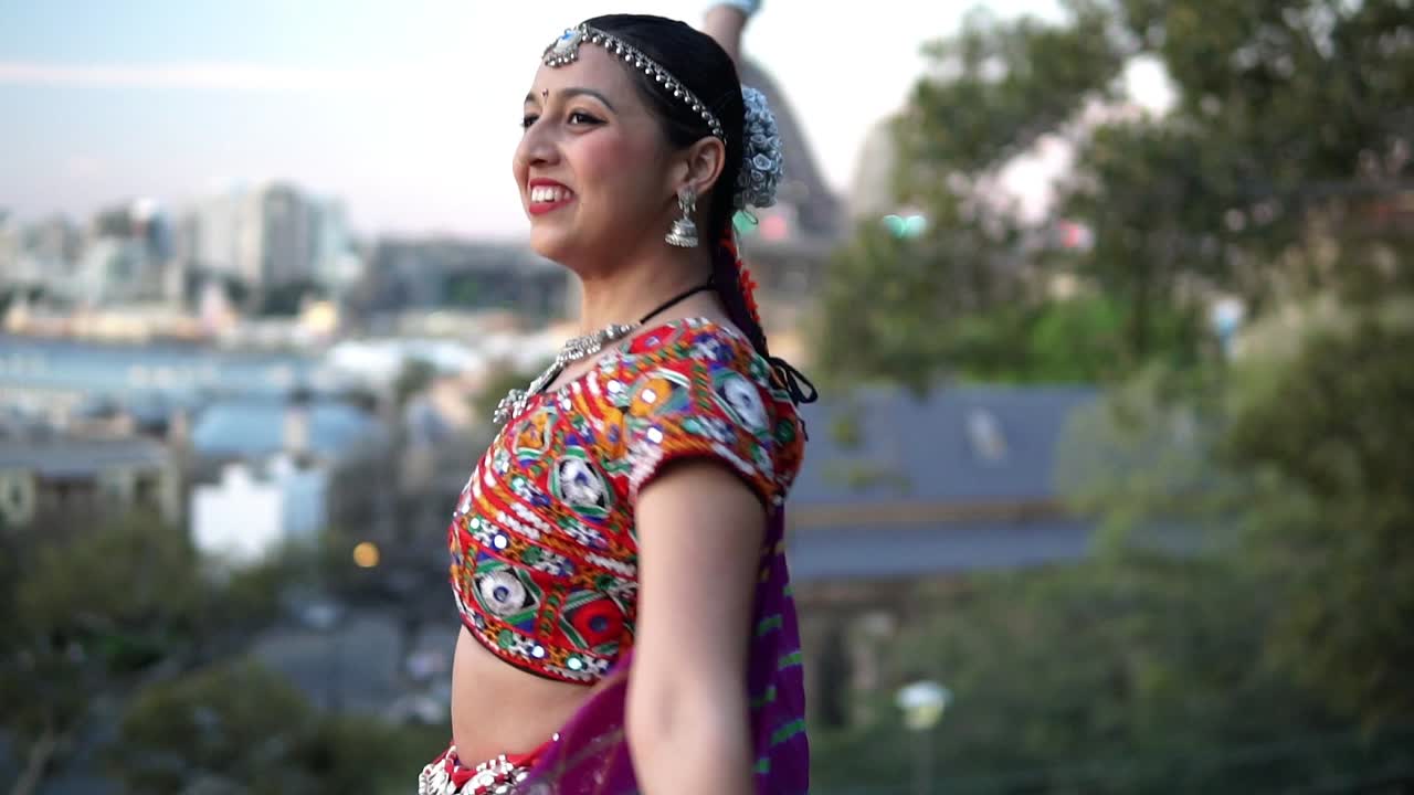 Donna dell'Asia meridionale che esegue una danza classica indiana in un giardino in Australia - media.