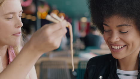 Amigas-Comiendo-En-Un-Restaurante-Dos-Mujeres-Disfrutando-De-Una-Deliciosa-Comida-De-Fideos-Ramen-Con-Palillos-Divirtiéndose-Juntas-Socializando-El-Fin-De-Semana-4k