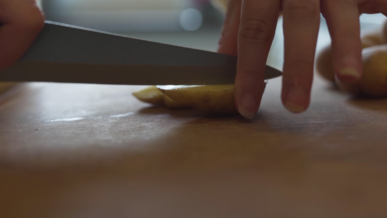 una mujer en la cocina colocando trozos de zanahorias y papas en una bandeja de horno lista para ser horneada en el horno-2