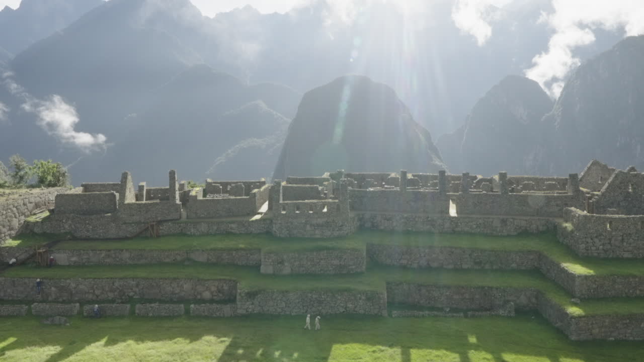 Zoom out to Machu Picchu lost city sunny day with peruvian mountains landscape. Wide shot panorama