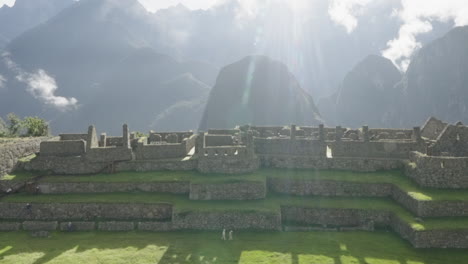 zoom out to machu picchu lost city sunny day with peruvian mountains landscape. wide shot panorama