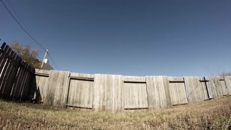 time lapse - shadows slowly across a wooden fence in a yard on a clean sunny day