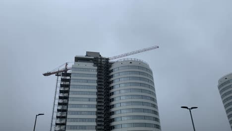 wide shot of spinning crane over new modern hospital during cloudy day in muenster,germany