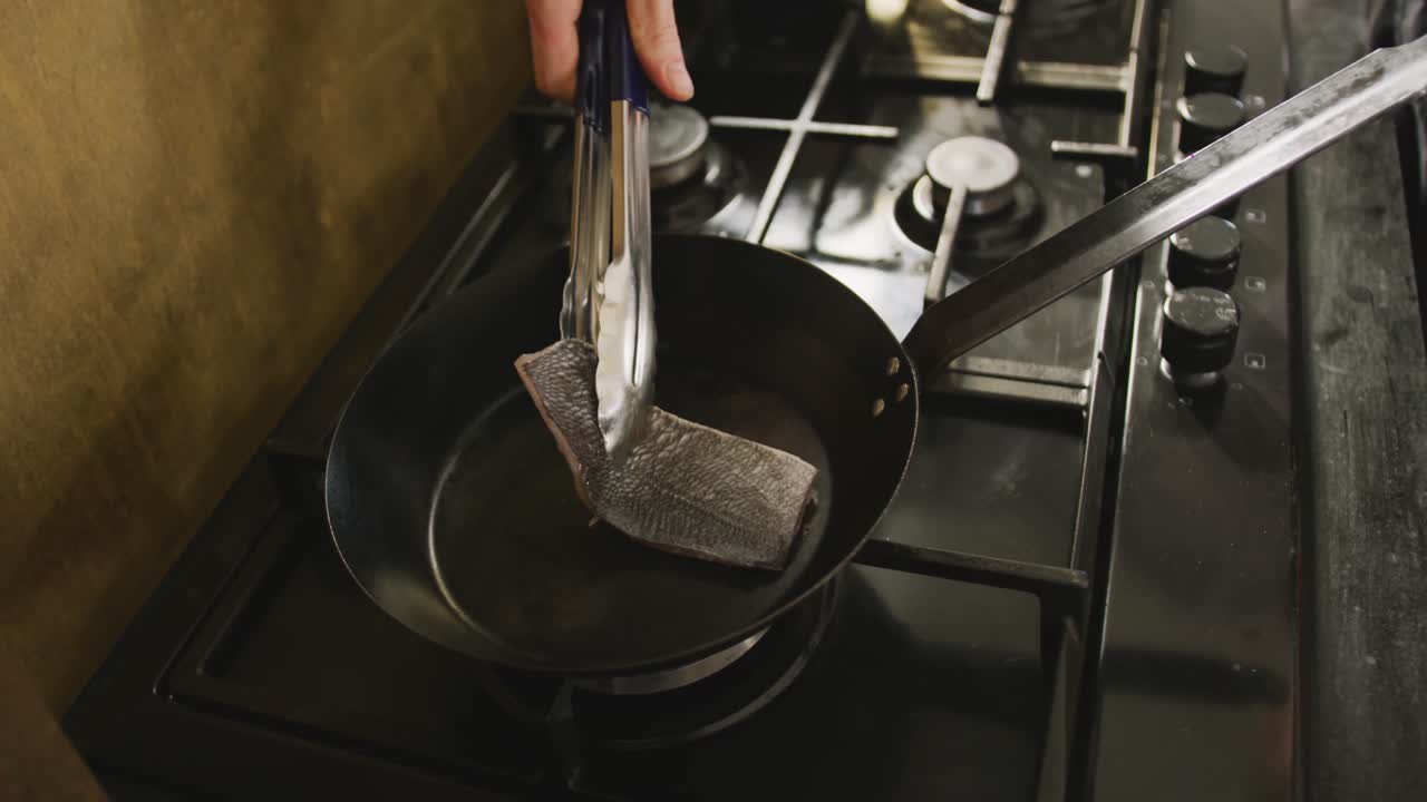 요리사 가 물고기 를 요리 하고 있다