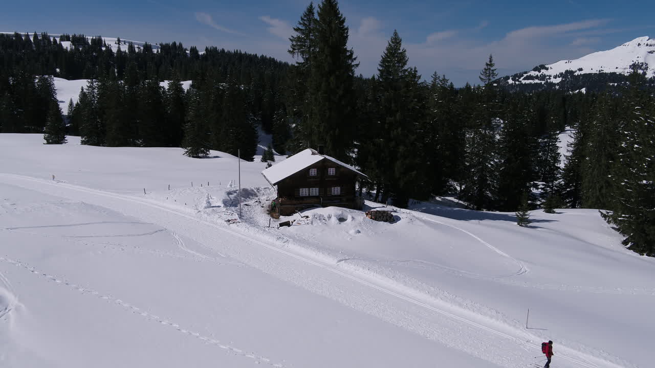 Winter in the Mountains. Fly away from a Chalet.
Some people are skiing.