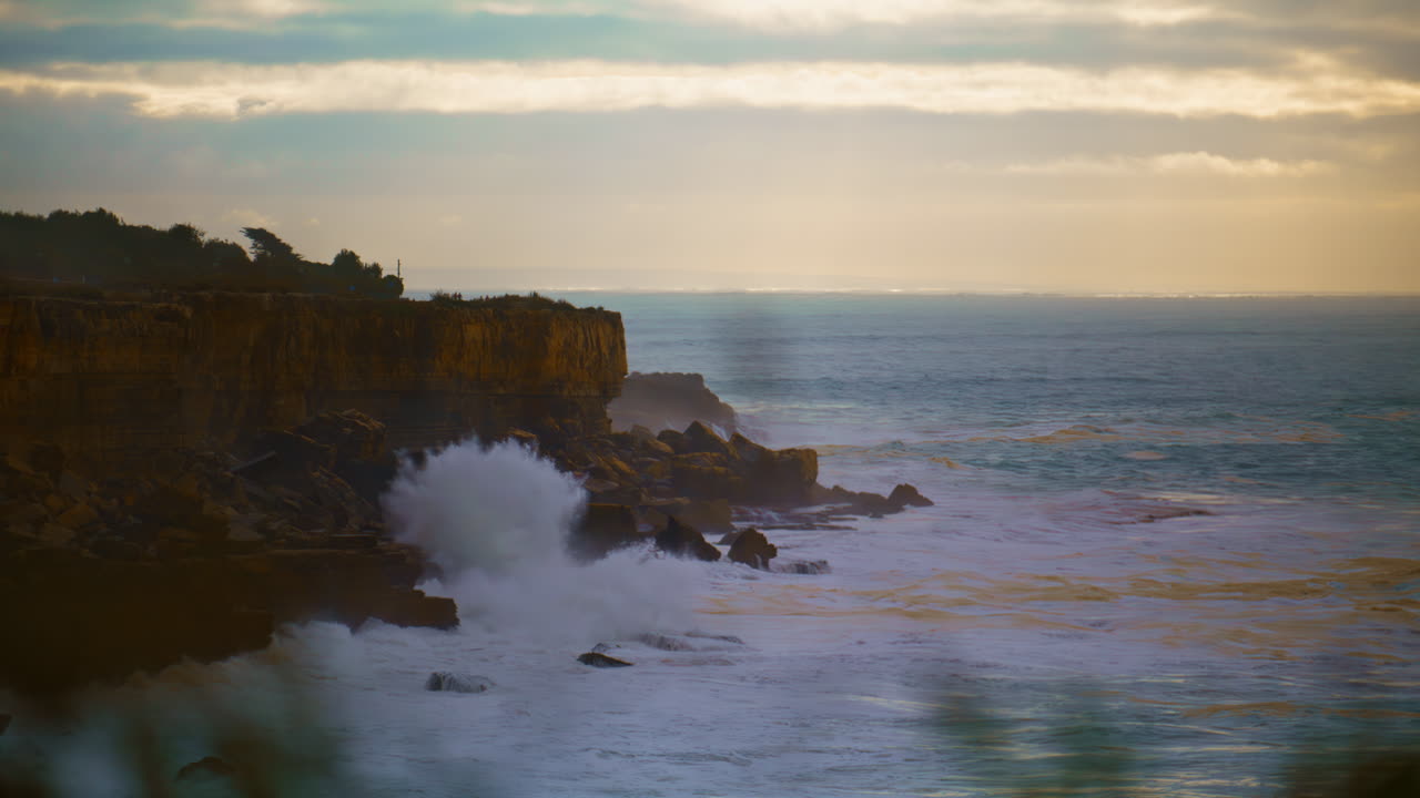 hermosas olas del océano chocando contra los acantilados por la mañana. un paisaje marítimo sereno en un cielo nublado.