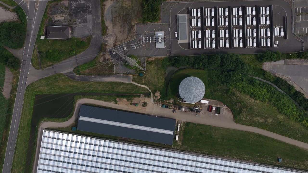 Aerial view of a large battery energy storage system beside a fossil fuel power plant in Germany, showing grid storage, electricity infrastructure and the energy transition.