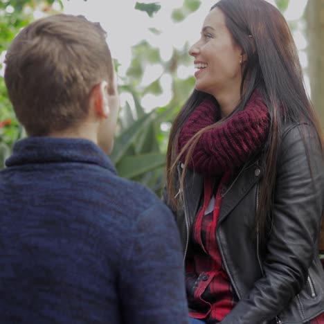 joven en cuclillas hablando con su novia