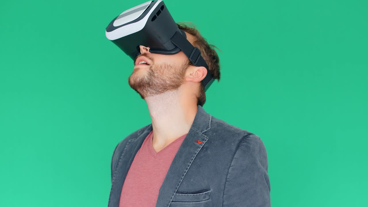 joven usando gafas modernas de realidad virtual en un fondo de pantalla verde, 4k
