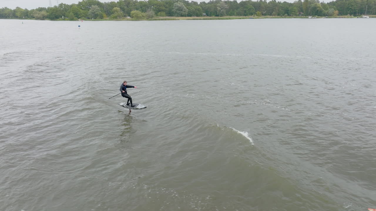 dos surfistas de hidrofolio surfeando en una ola detrás de un barco en un río en alemania