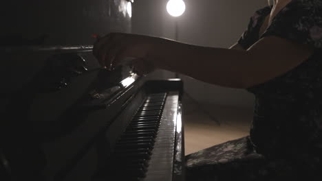 pianist opens the fallboard of a vertical piano and reveals the keyboard