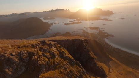 Diving-a-beautiful-mountain-crest-over-Rambergstranda-Beach-at-sunset,-Lofoten-Islands-in-Norway