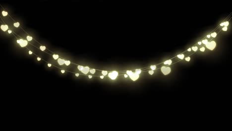 animación digital de luces de hadas decorativas en forma de corazón colgadas contra un fondo negro