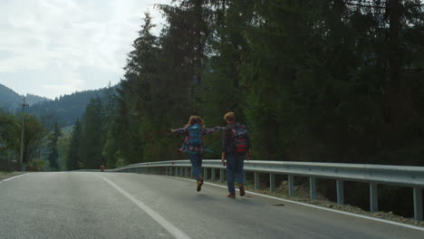 amigos caminando por las montañas en la naturaleza del bosque. la pareja usa mochilas afuera.