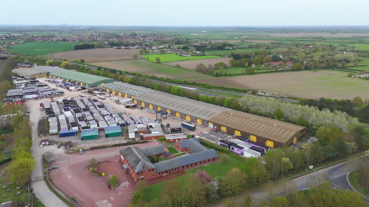 Aerial drone view warehouse business area with train passing railway line England UK economy transport logistics