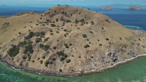 una vista de drone que revela una isla árida y estéril rodeada por un rico arrecife de coral