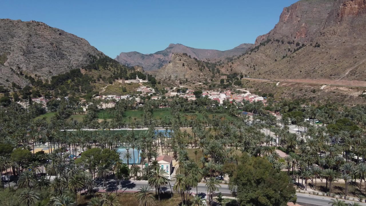 Toma de dron del distrito de San Antón en Orihuela rodeado por el icónico palmeral y montañas áridas