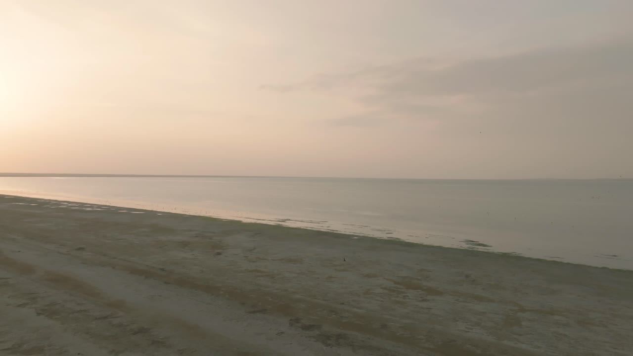 una vista aérea impresionante de la extensa gran rann de kutch salt marsh mientras el sol se pone, arrojando tonos cálidos sobre el paisaje sereno en el desierto de thar de gujarat