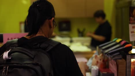 person waits at counter in hong kong