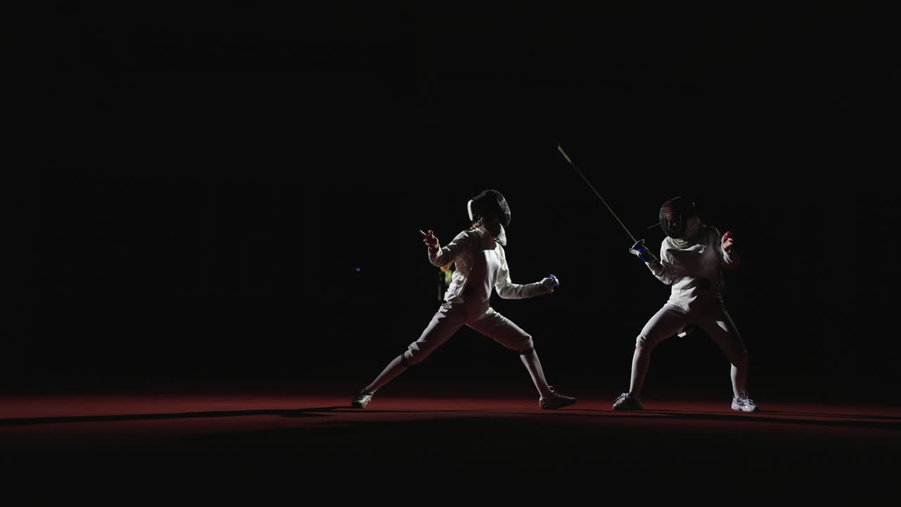 Two female fencers compete in a match