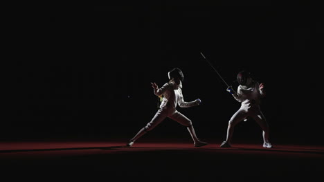 two female fencers compete in a match