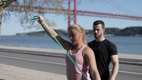 two young people training near road on riverside.