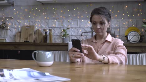 mujer usando el teléfono en una cocina acogedora