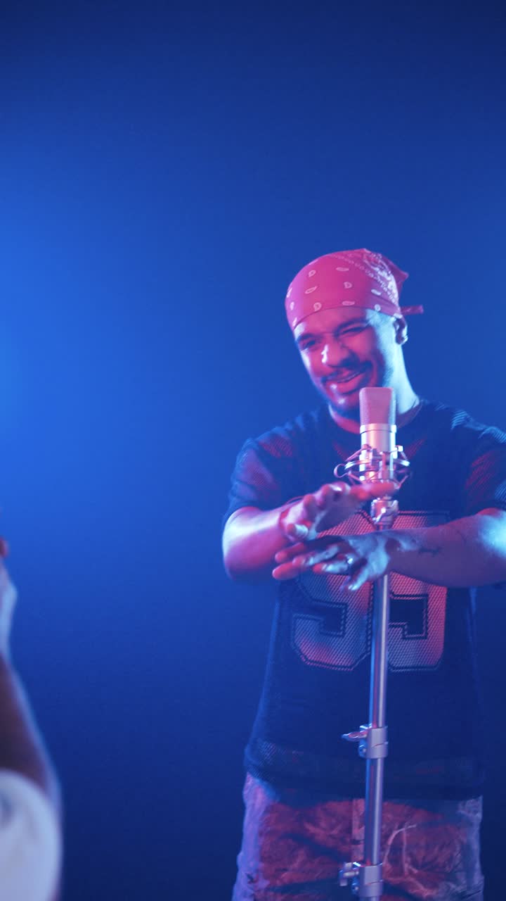 Rapper bernyanyi ke mikrofon untuk video media sosial. Vertikal