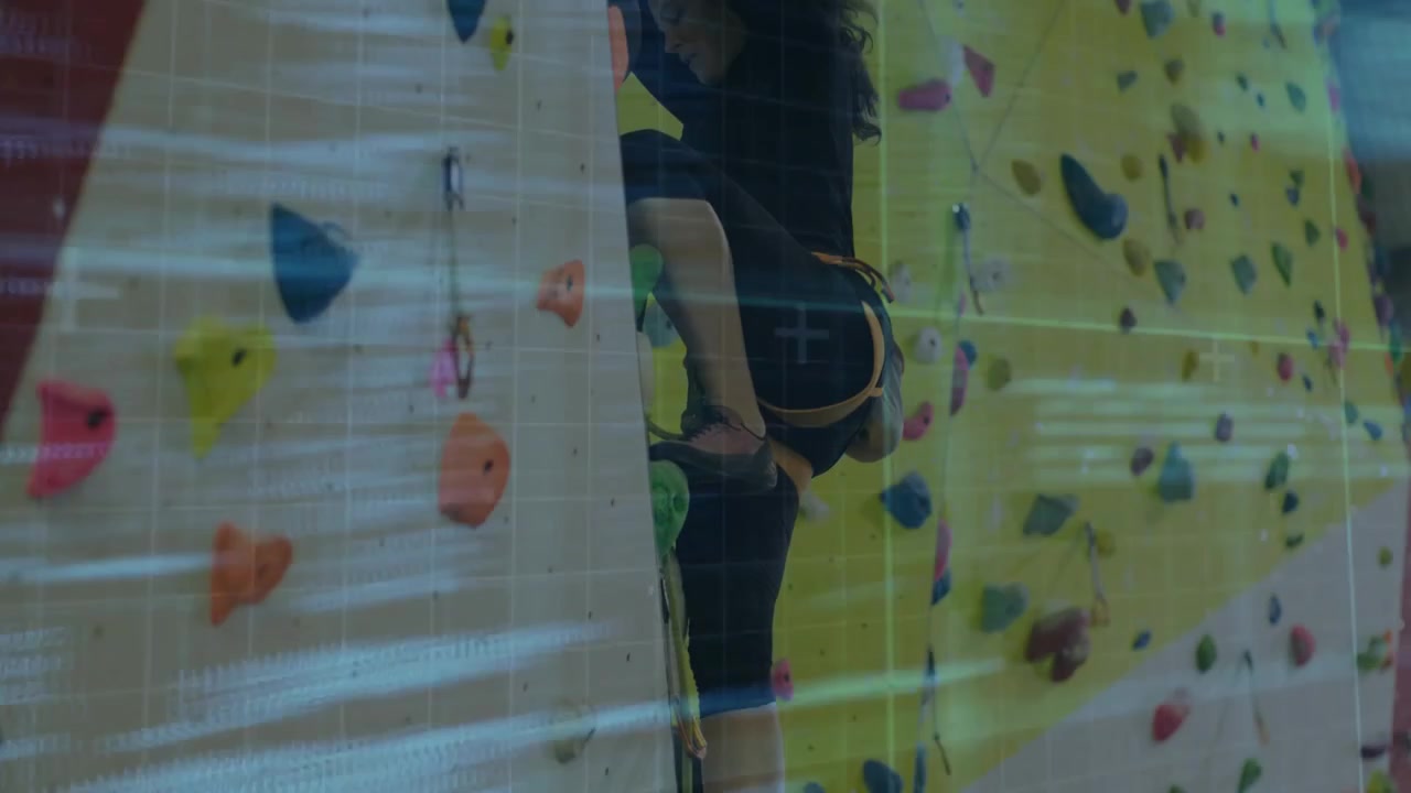 Code overlay drifting revealing woman gripping holds, ascending yellow wall for fitness training