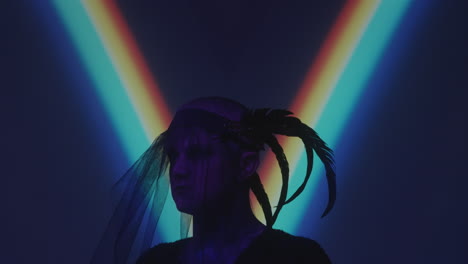 man in gothic veil with feathers in dark studio