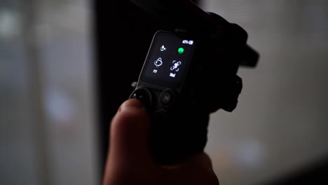 Close-up-of-small-gimbal-stabilizer-screen,-person-finger-push-joystick