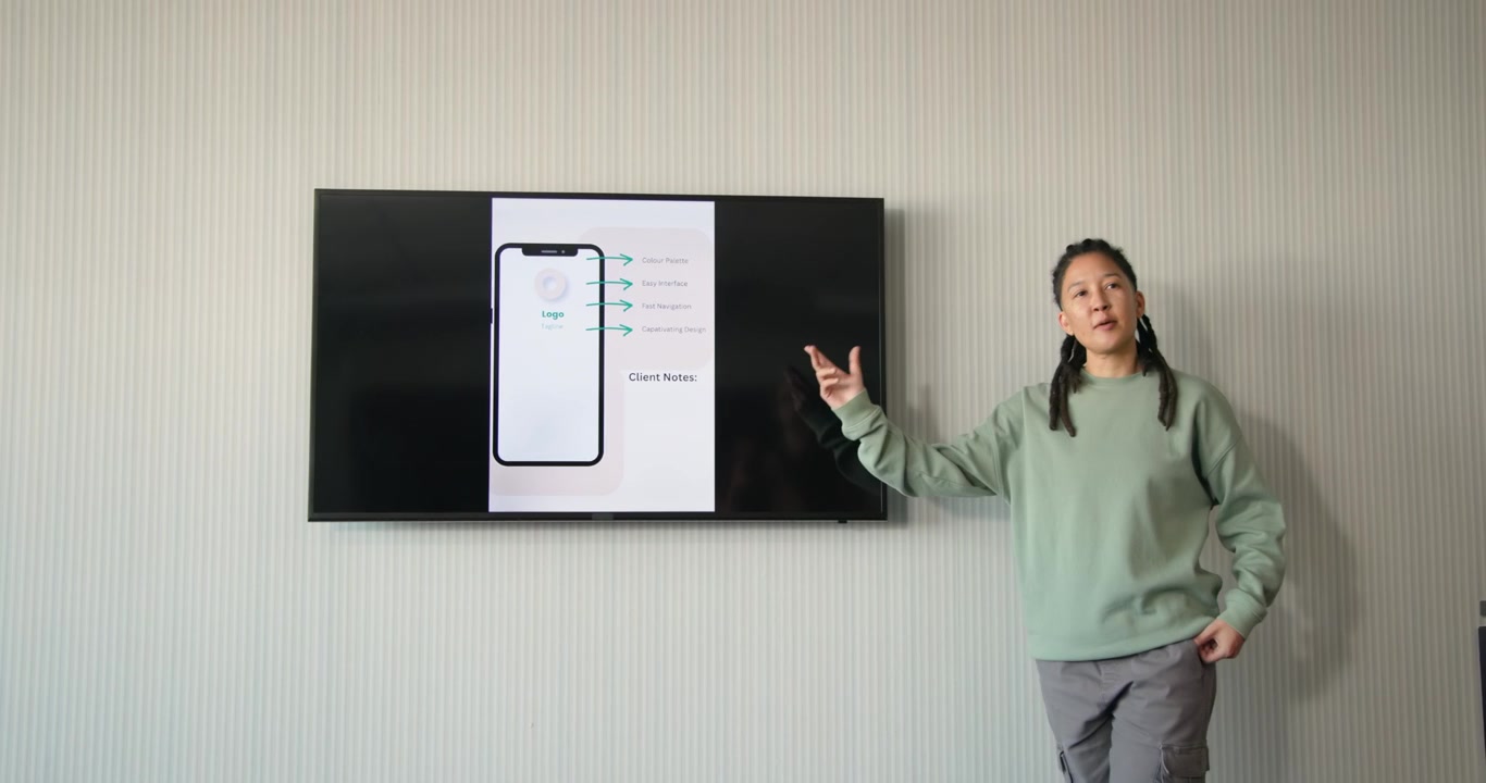 Nonbinary African American presenting in meeting reaching screen, walking, pointing at Client Notes