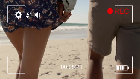 holding hands, couple walking on beach with recording animation overlay