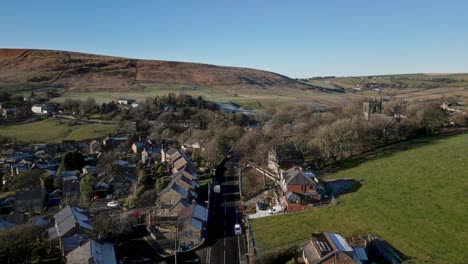 aerial footage of the village of denshaw, and the church and graveyard, a typical rural village in the heart of the pennines