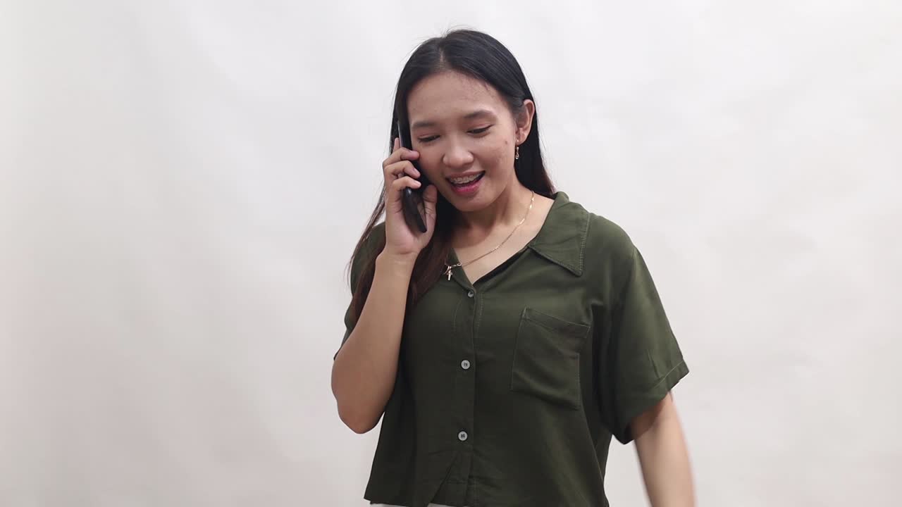 Young Asian woman looks excited and happy when she receives some news or message from her mobile phone