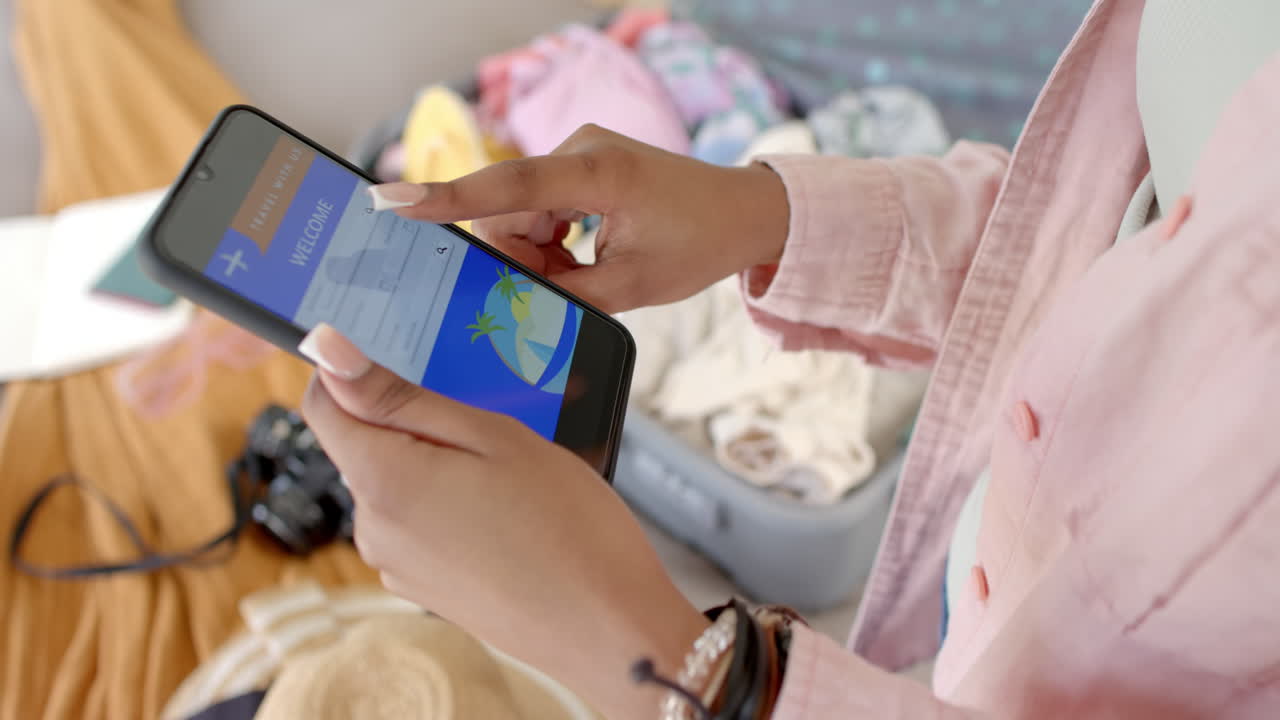 African American young woman booking travel on smartphone