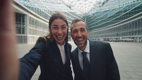 cinematic shot of smiling business colleagues making technology video call to partners before meeting on office skyscrapers background. concept: network, connection, communication, success, internet.
